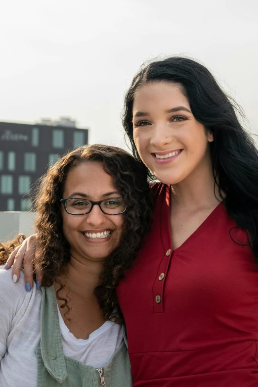 two young women smile and hug while posing for a picture