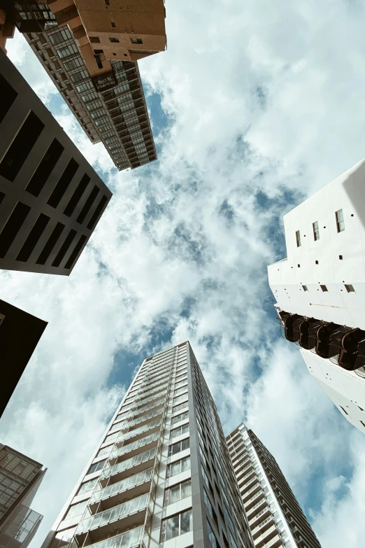 tall skyscrs stand beneath a cloudy blue sky