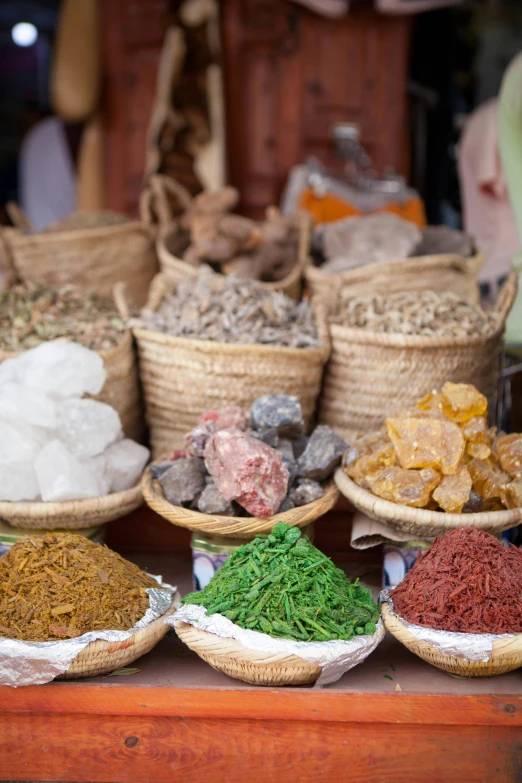 various types of spices are sitting in baskets