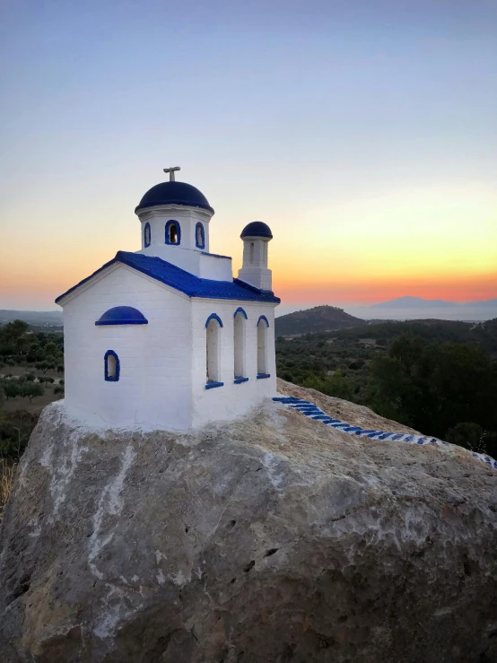 an old church sitting on a hill with two crosses