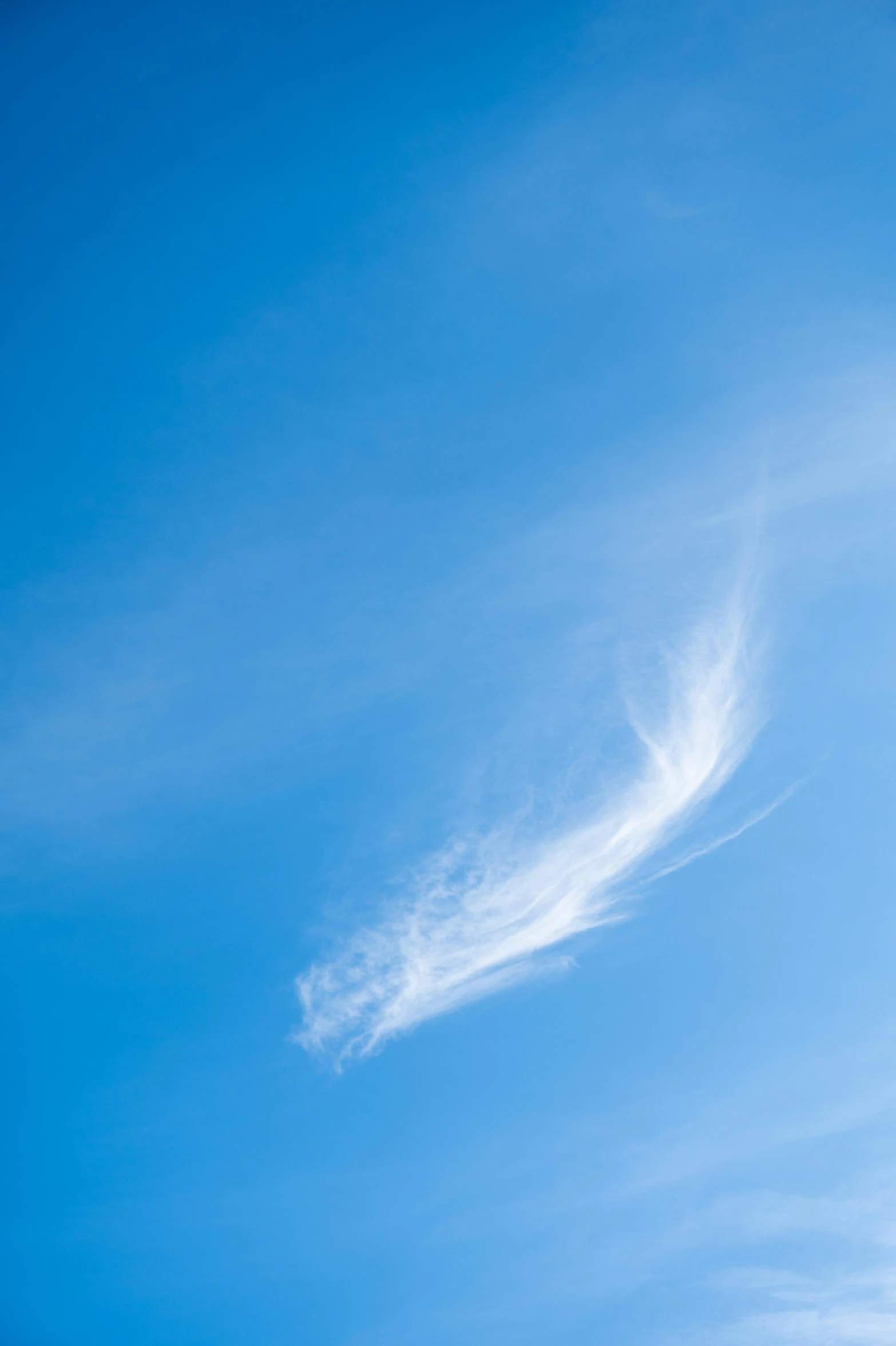 airplane flying in the sky with contrails across the clouds