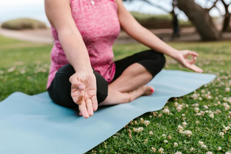 the woman is sitting on the yoga mat doing a stretching exercise