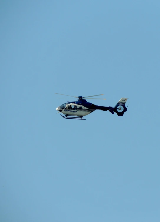 an ornate bell helicopter flies in the blue sky