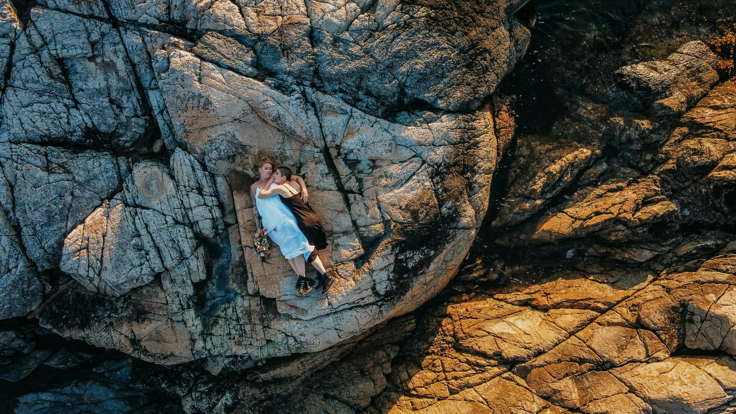 an aerial s of two people standing on a rock formation