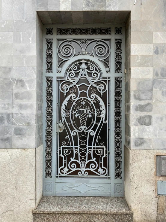 an elaborate iron door on the side of a building