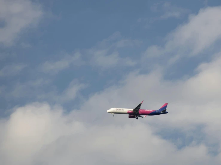 the airplane was soaring above the clouds in the blue sky