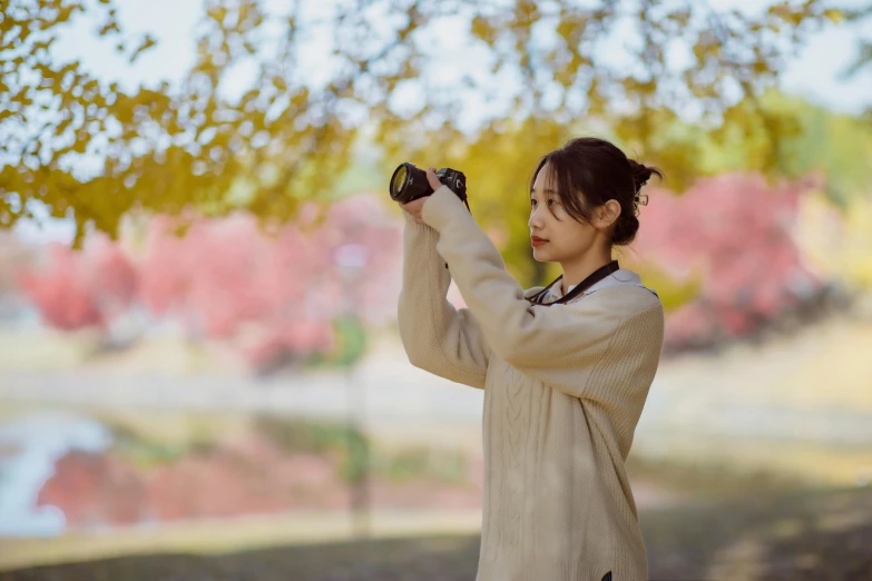 an asian woman holds up a glass container to take the picture