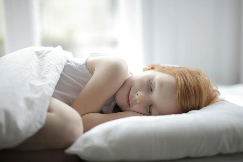 a  lying in bed smiling for the camera