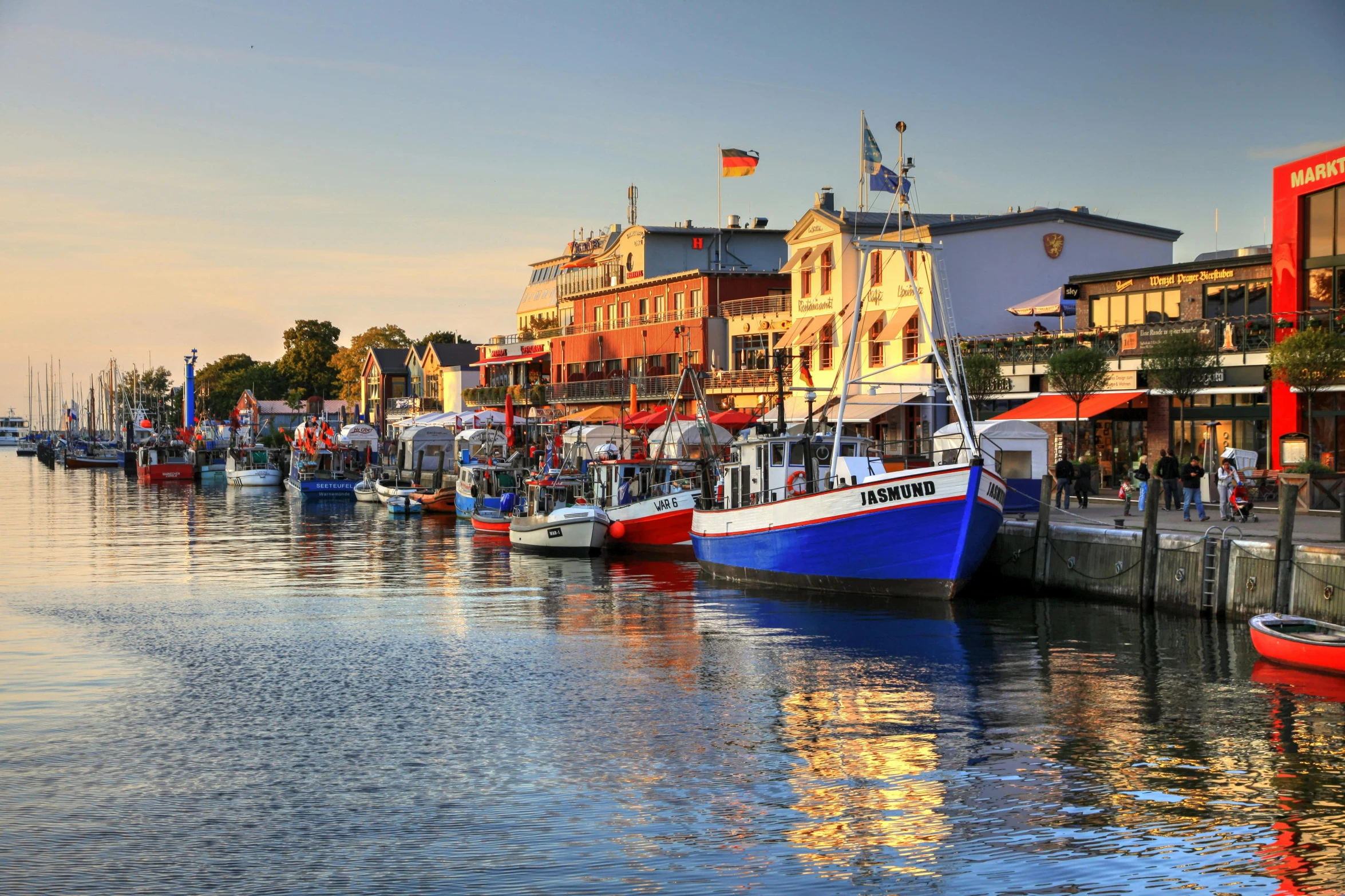 several boats are parked at a dock near a city