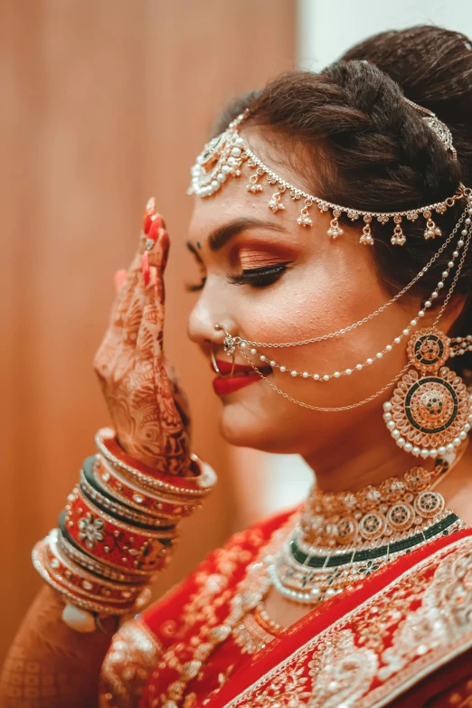 a woman dressed in traditional indian attire and jewelry