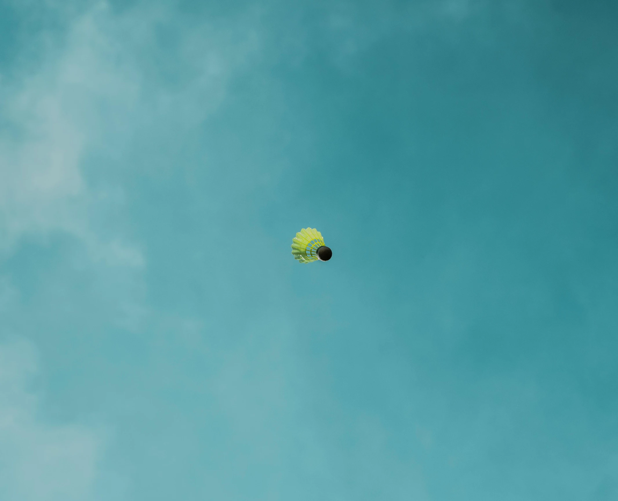 a yellow kite is flying through the blue sky