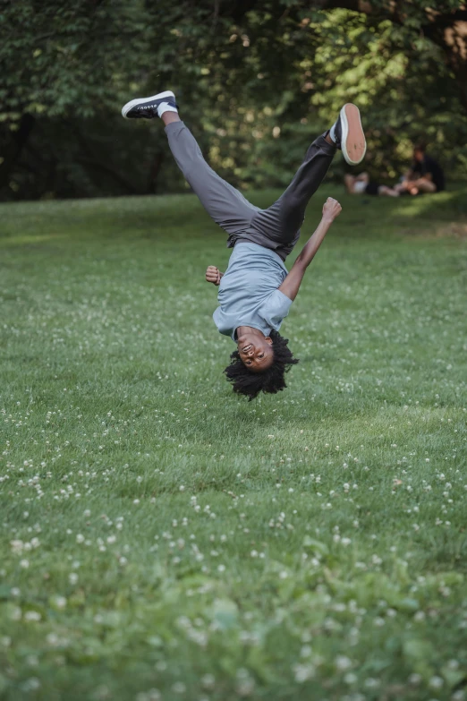 a person upside down doing a trick on the grass