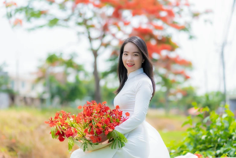 a beautiful woman in a wedding dress holds up some flowers