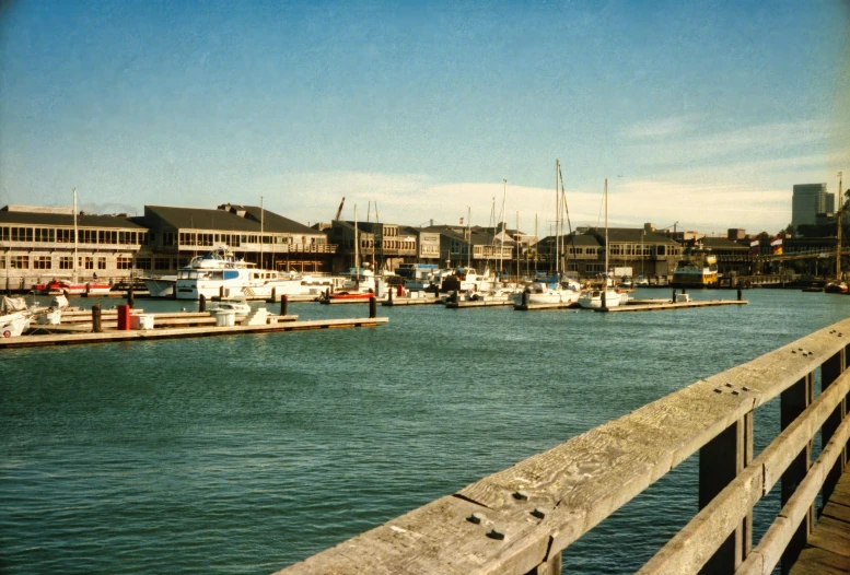 a marina and docks with boats parked and houses on the other side