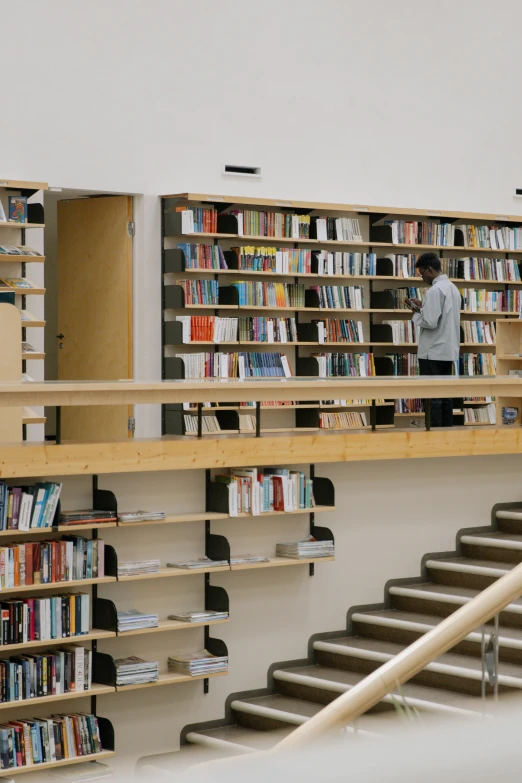 a man standing in front of an aisle full of books