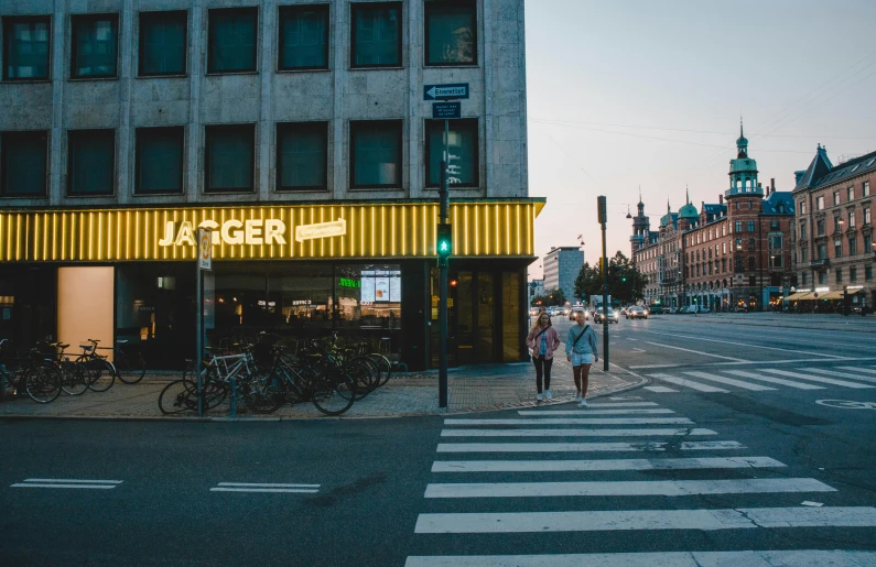 people walking down the street by a tall building