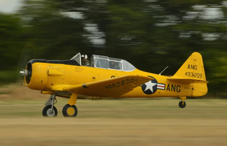 yellow plane with large propellors taking off