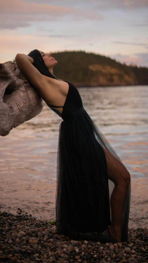 woman posing on the shore of lake with head on body of water