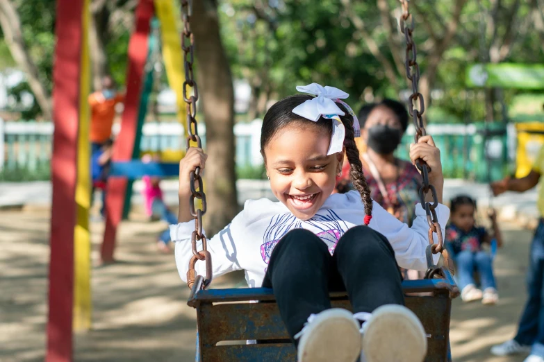 a  sitting on a swing at a park