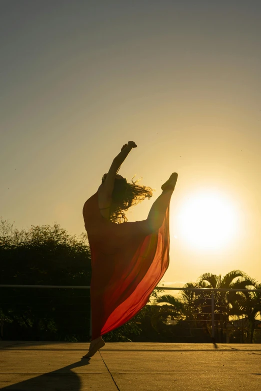 woman is jumping in the air with a red dress