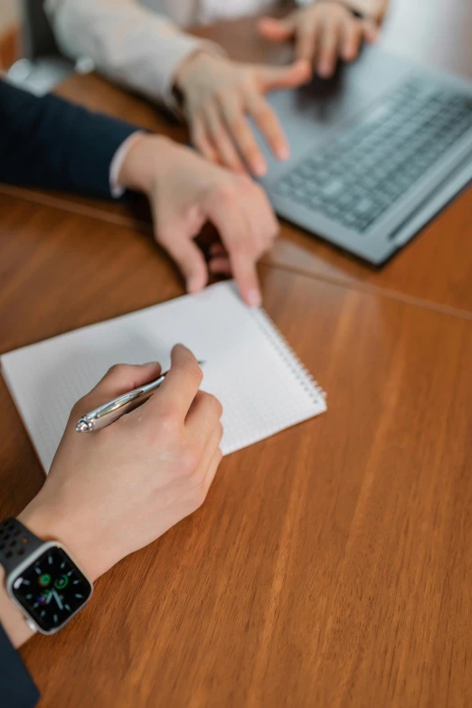 two people working on some type of project using an apple watch