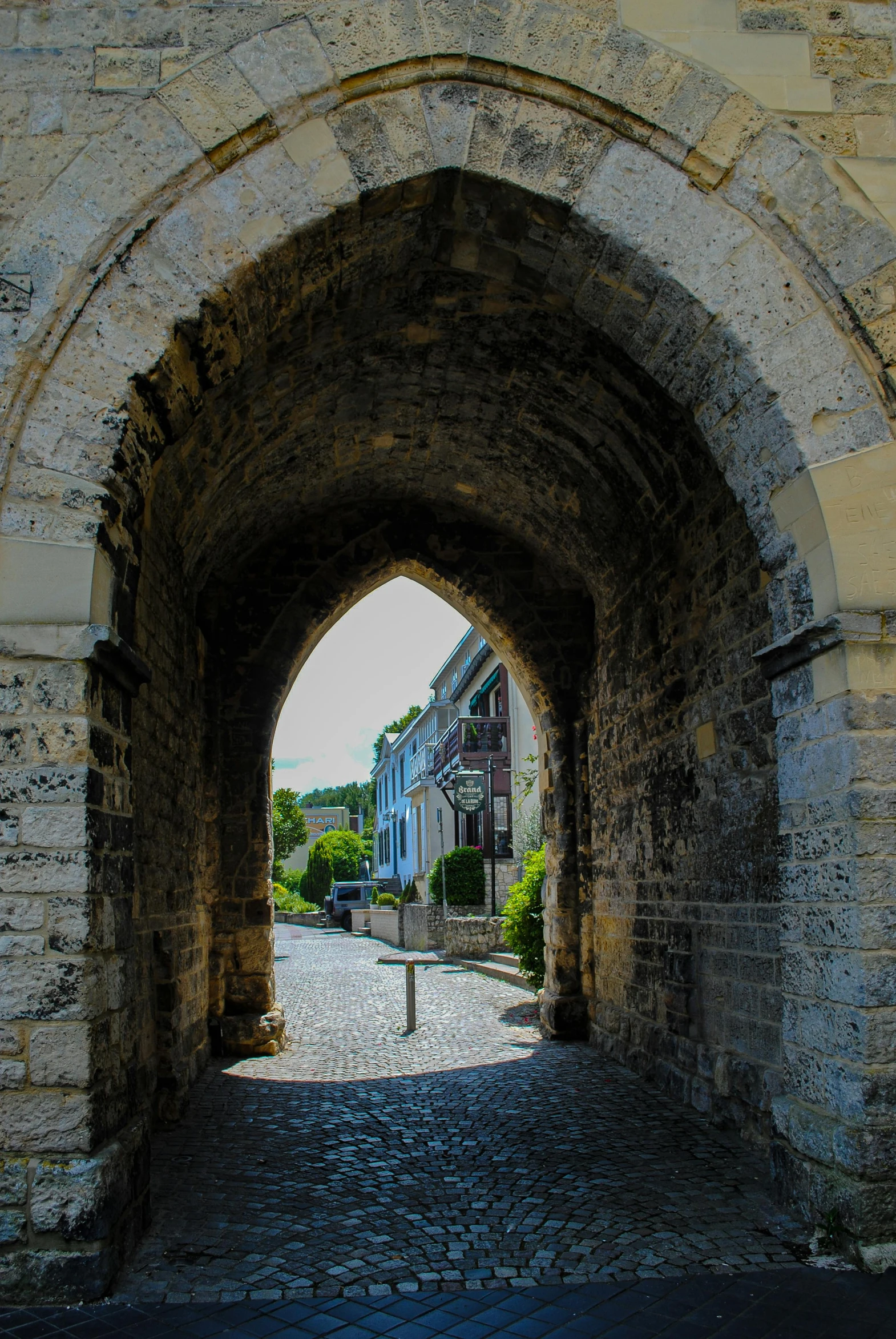 an arched doorway leading into a cobblestone area