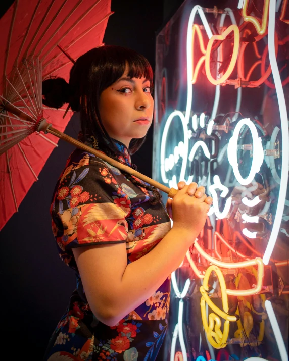 a woman in a floral shirt holds an umbrella