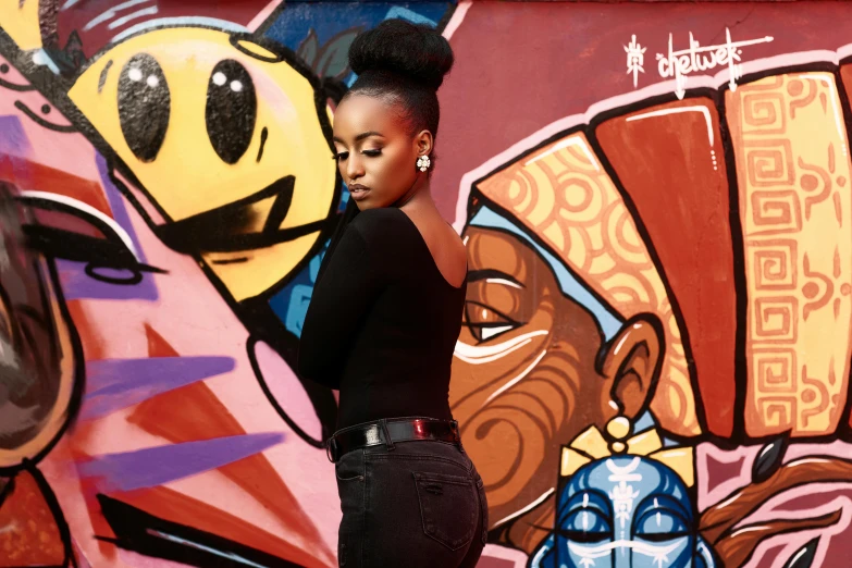 a young woman standing in front of graffiti