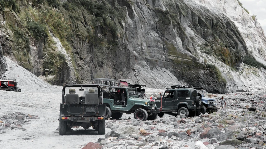 several jeeps parked near a rocky terrain area