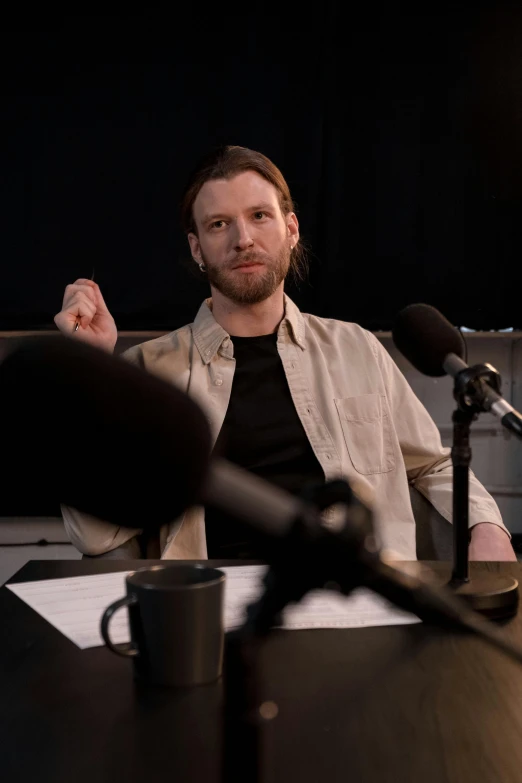 man sitting in a chair with a microphone