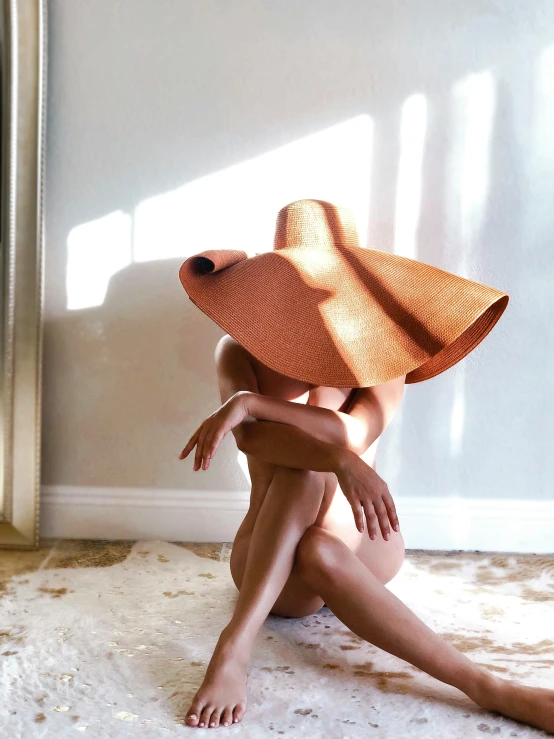 woman sitting on the floor with a straw hat on her head