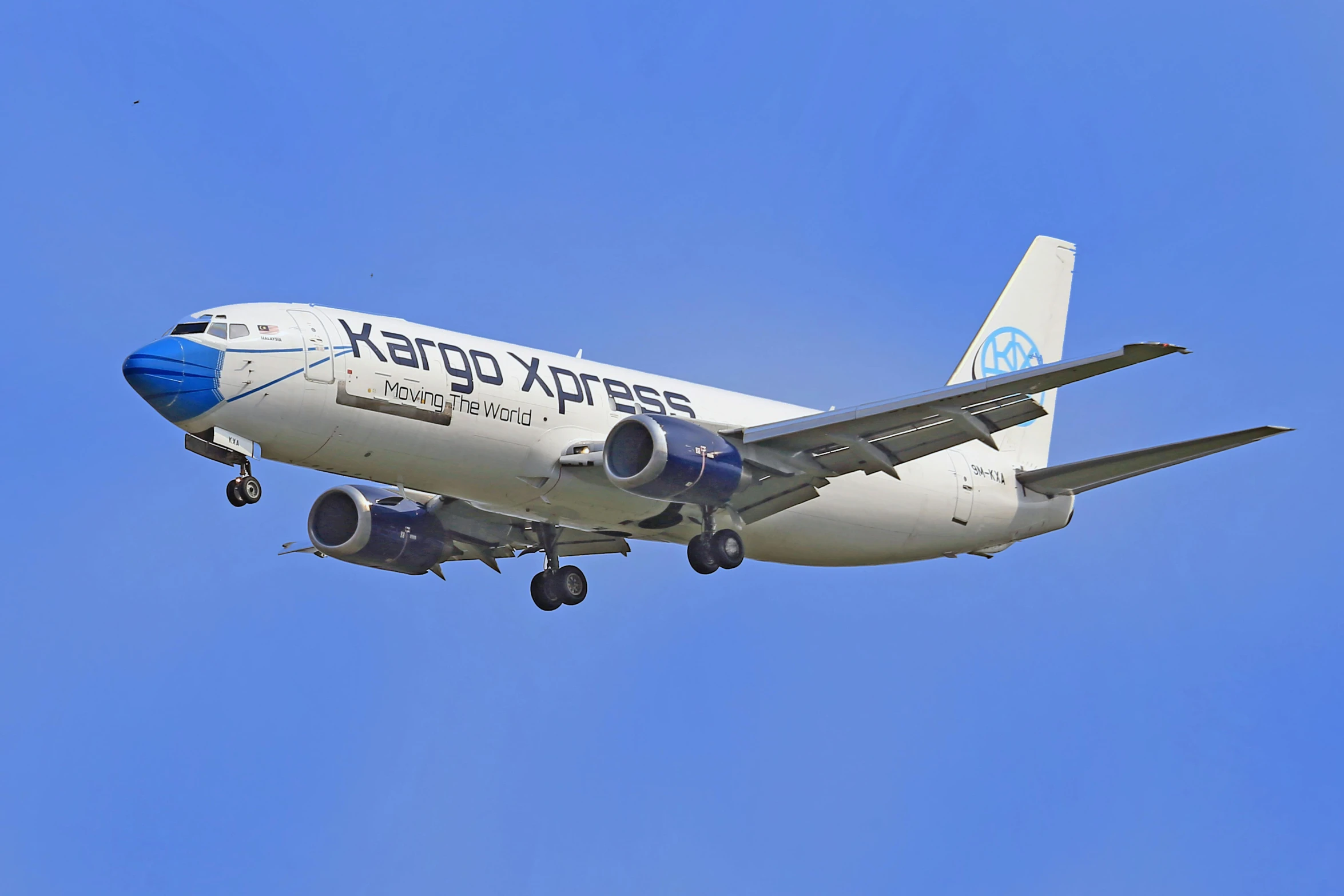 a blue and white jet airliner in flight