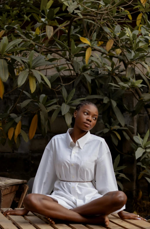 an african woman wearing a white shirt and a wooden floor, with one foot in the air