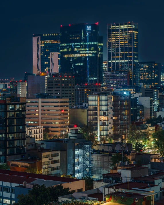 a large city at night, illuminated by several tall buildings