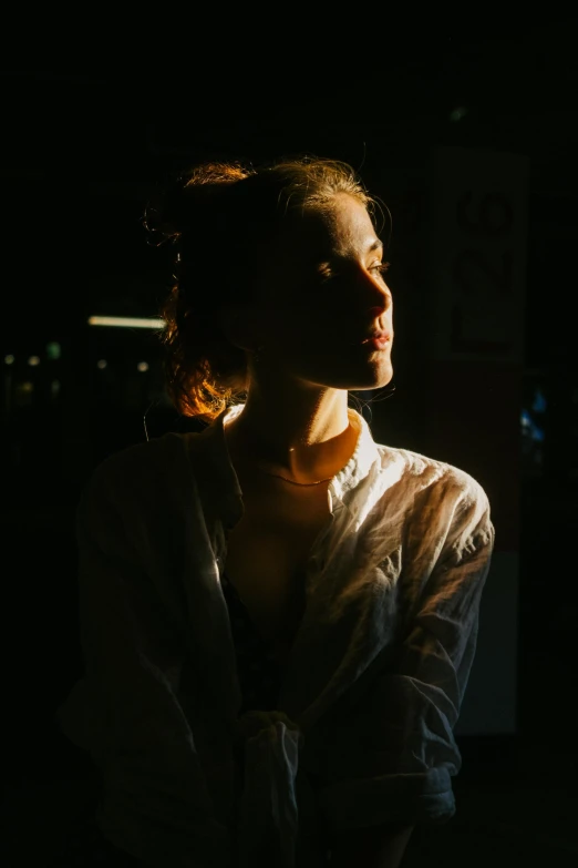 a dark image of a woman in white blouse