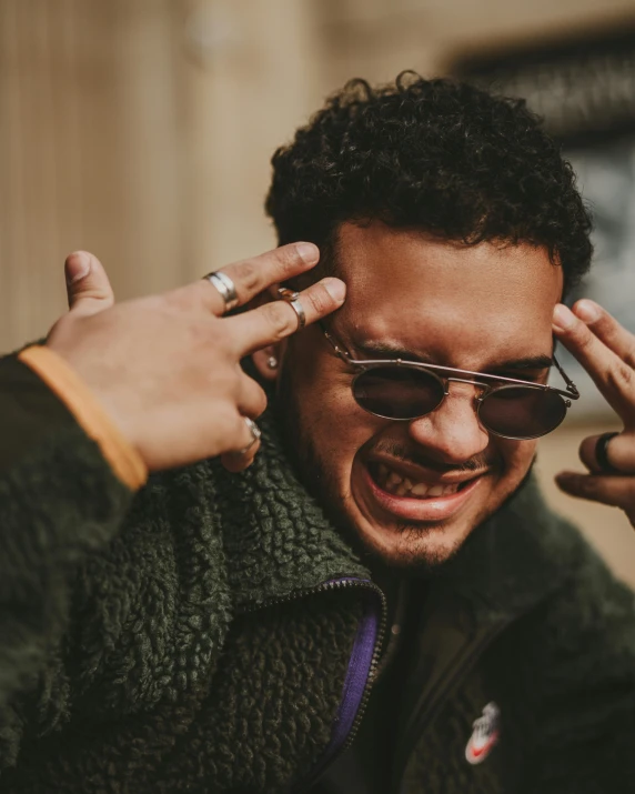 a man putting sunglasses on his head talking on his cell phone