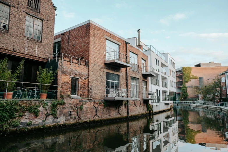 a canal in the center of a city with brick houses on both sides