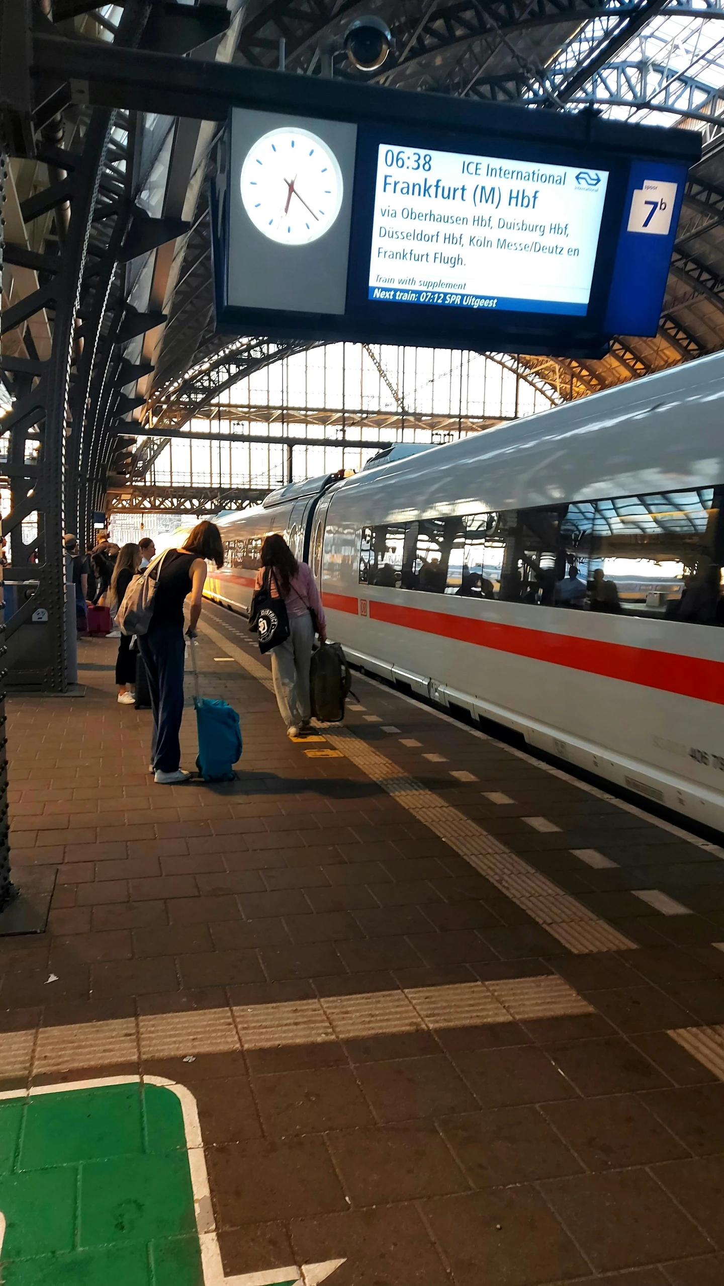 people are loading luggage at a public transportation area