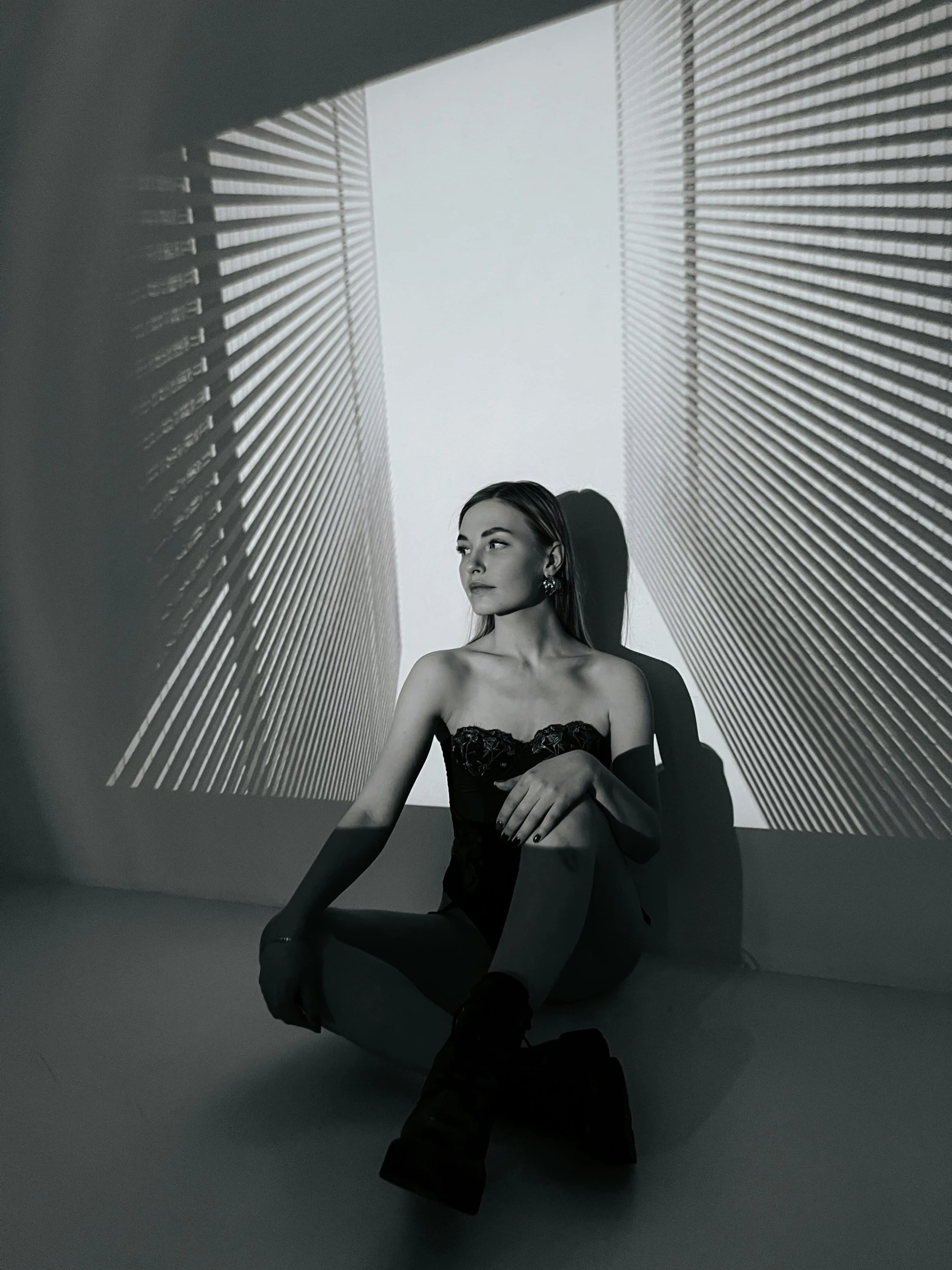 a woman is sitting in an empty room with her feet on the ground