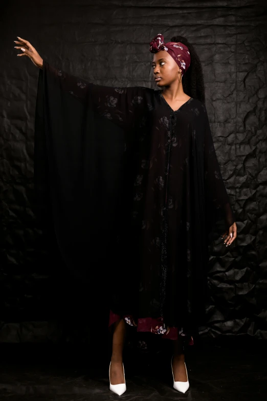 a woman holding a black shawl over her shoulders