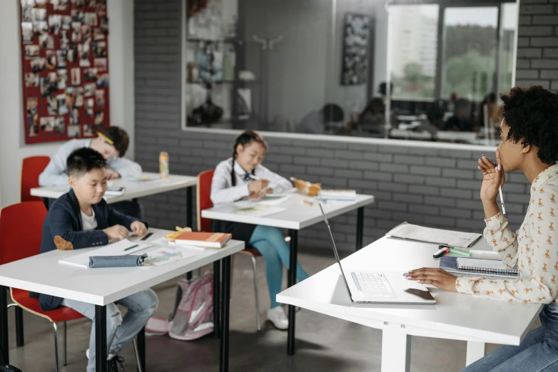 students sit at their desks in a classroom and look on