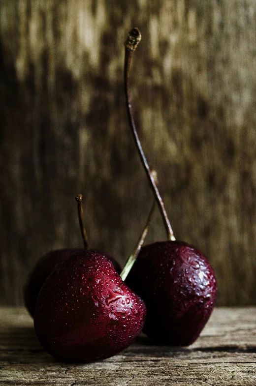 two apples with red fruit on a wooden table