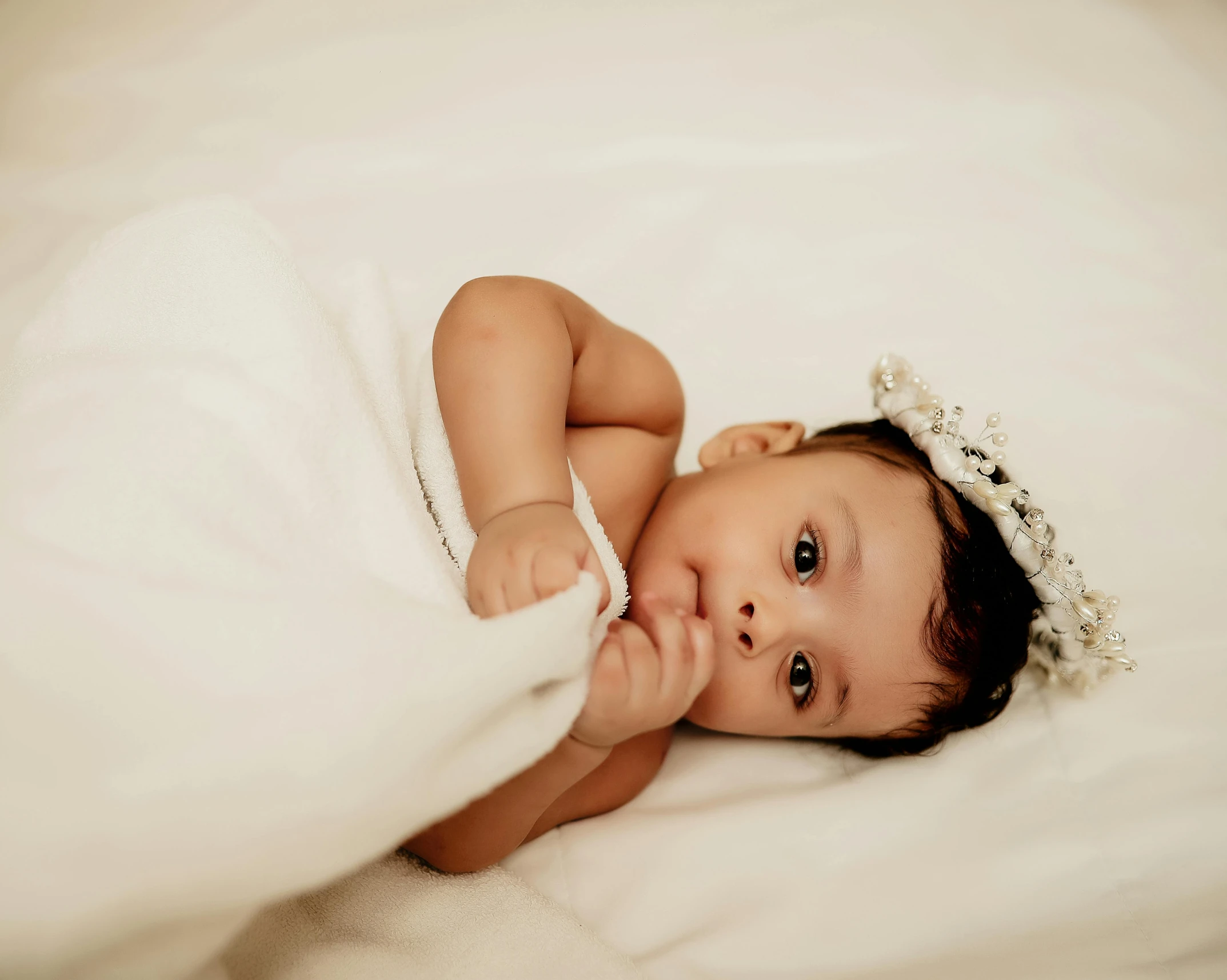 a little baby with a tiara on it laying down