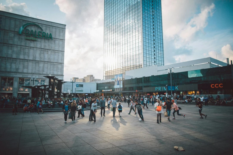 people walk in the center of the street with tall buildings