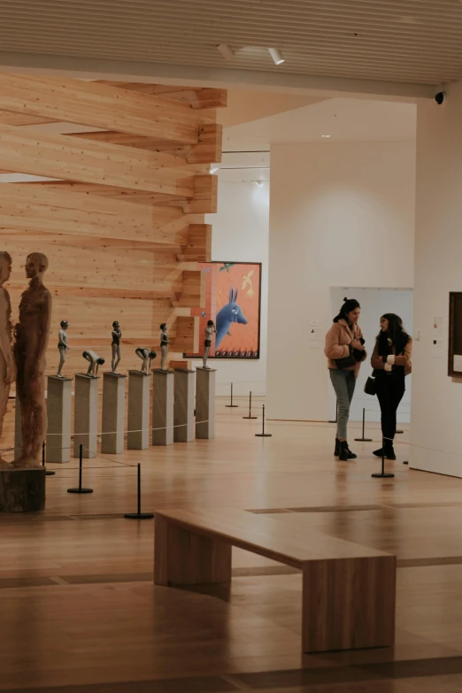 people looking at art on display inside of a museum