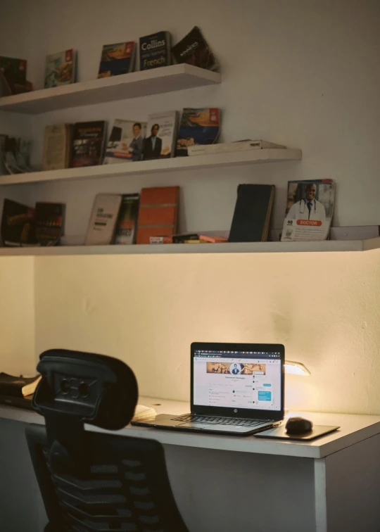 a desk with a laptop and some books on it