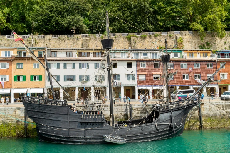 the black ship is in the harbor near buildings