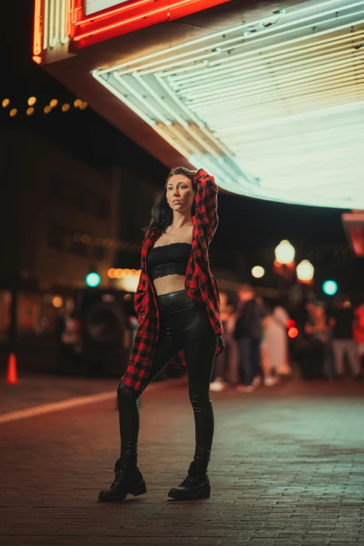 a woman in black pants is holding a red and white jacket