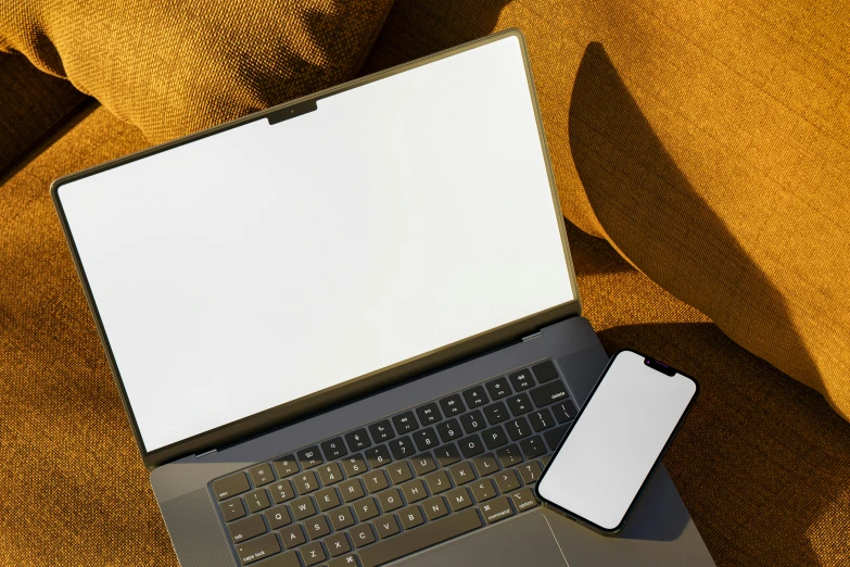 an open laptop computer sitting on top of a yellow couch