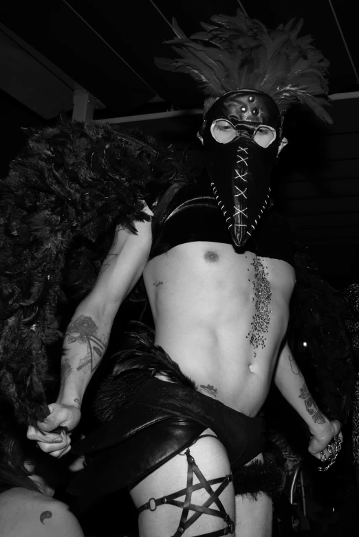 a person wearing an extreme mask with leather stockings and skirt